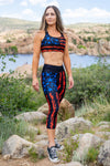 Woman wearing a patriotic set of activewear, capris and sports bra in black red and blue with gun flags of the USA and blue stars out on a hike in arizona by watson lake