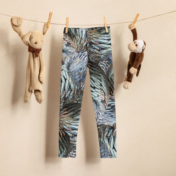 Childrens turkey feather pattern leggings hanging on a clothes line with toys