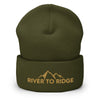 River to Ridge Logo stitched on a beanie. Logo is gold with mountains and hat is green