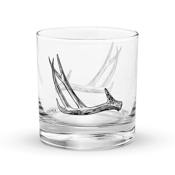 Product mockup of a whiskey rocks glass with deer antler shed hunting logo  on it from River to Ridge Brand