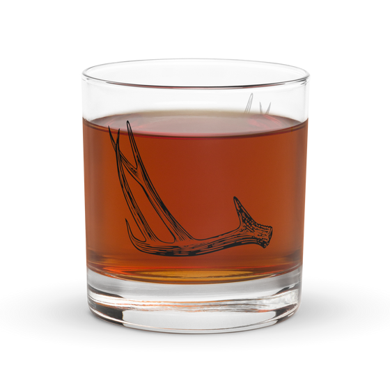 Product mockup of a whiskey rocks glass with deer antler shed hunting logo  on it from River to Ridge Brand