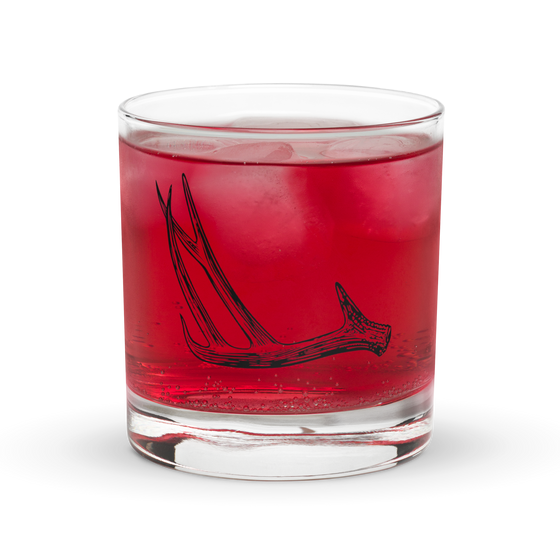 Product mockup of a whiskey rocks glass with deer antler shed hunting logo  on it from River to Ridge Brand with a Pink Drank