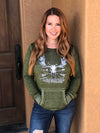 Woman with red hair wearing a Rockstarlette Outdoors hoodie in green with a moose and archery arrows on it, bowhunting