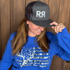 R to R River to Ridge Clothing Brand Logo Trucker Hat in charcoal with silver stitching worn by a red head woman in a whitetail buck flag t shirt