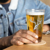 Product mockup of a pint beer glass with whietail deer skull logo from River to Ridge clothing brand