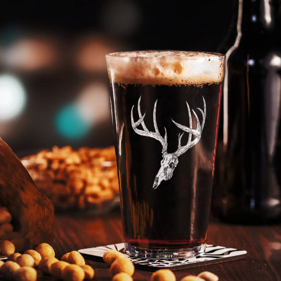 Product mockup of a pint beer glass with whietail deer skull logo from River to Ridge clothing brand