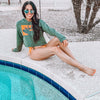 Woman at the pool on diving board wearing a River to Ridge brand cropped Elk Logo hoodie and bikini bottoms in green and orange