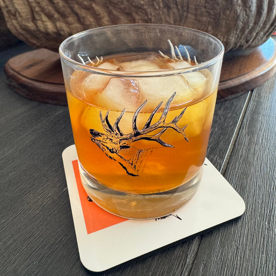 Whiskey Rocks glass with cocktail in it and elk printed on glass from River to Ridge Clothing Brand