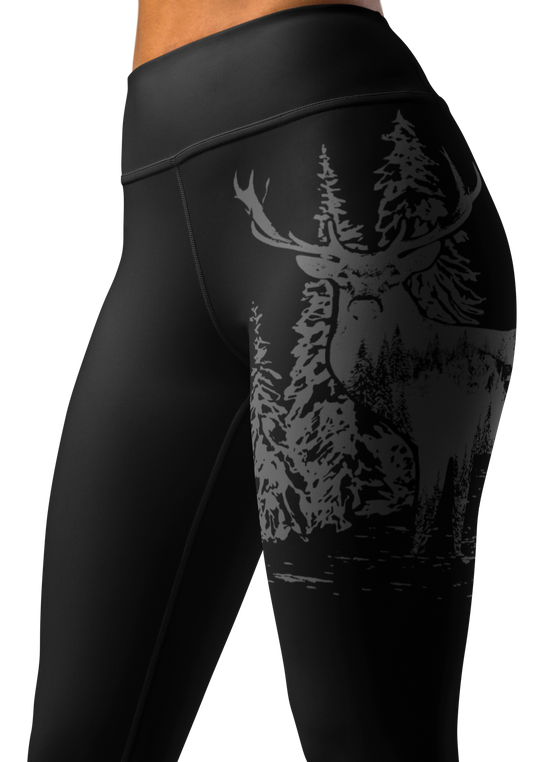 close up of a woman wearing leggings with a wide waistband and a logo of an elk red stag on it in black and grey