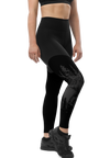 Woman's leggings in black with woodland elk deer design on them, she is wearing a black top and black shoes