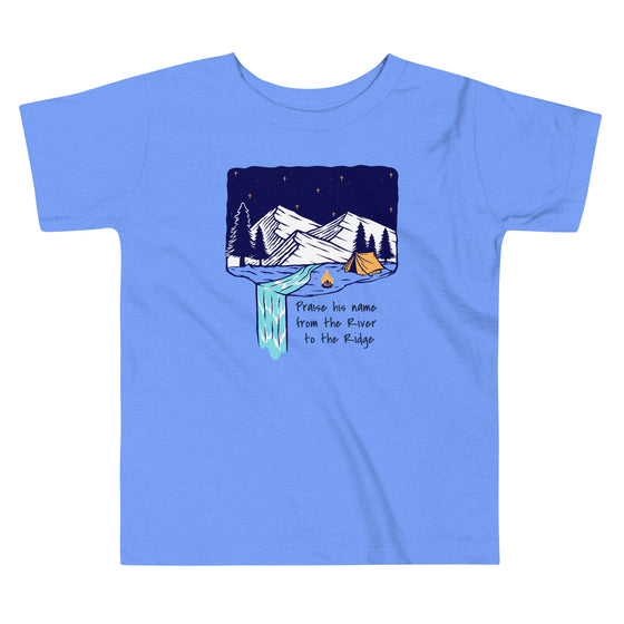 Product mockup of a Christian Scripture T shirt from River To Ridge clothing for children with a waterfall and camping tent on it