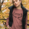 Product mockup of River to Ridge brand deer antler logo long sleeve t shirt in pink on a woman wearing a vest