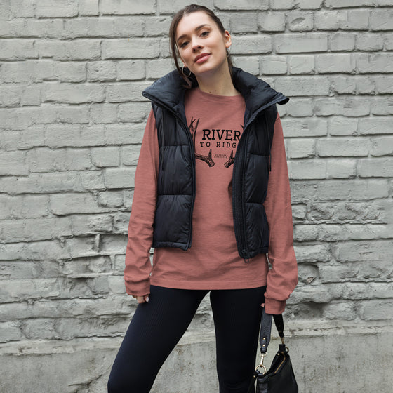 Product mockup of River to Ridge brand deer antler logo long sleeve t shirt in pink on a woman wearing a vest