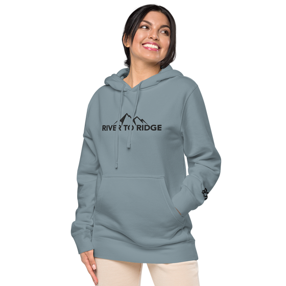 Indigo Blue Womens Hoodie with the River to Ridge Clothing Mountain Logo embroidered on the chest and cuff of sleeve. Worn by a pretty woman