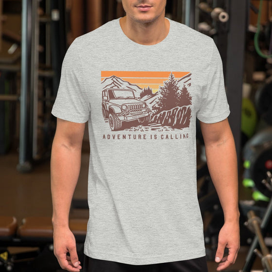 Man wearing a T shirt featuring a Jeep offroad and saying Adventure Is Calling from River to Ridge Clothing Brand at the gym