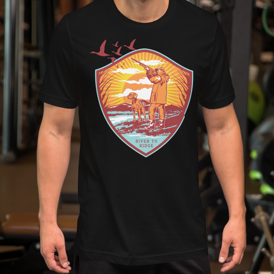 Product mockup of a waterfowl hunting t shirt of goose hunt with a man and dog on a guy at the gym in black