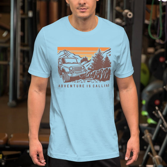 Man wearing a T shirt featuring a Jeep offroad and saying Adventure Is Calling from River to Ridge Clothing Brand at the gym