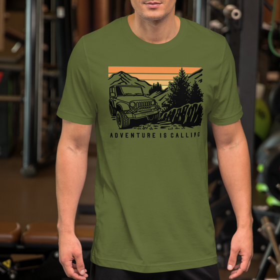 Men's T Shirt with graphic of a Jeep offroading in the mountains with the Words Adventure is Calling from River to Ridge Clothing brand worn by a man at the gym