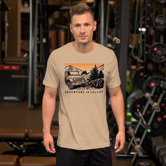 Men's T Shirt with graphic of a Jeep offroading in the mountains with the Words Adventure is Calling from River to Ridge Clothing brand worn by a man at the gym