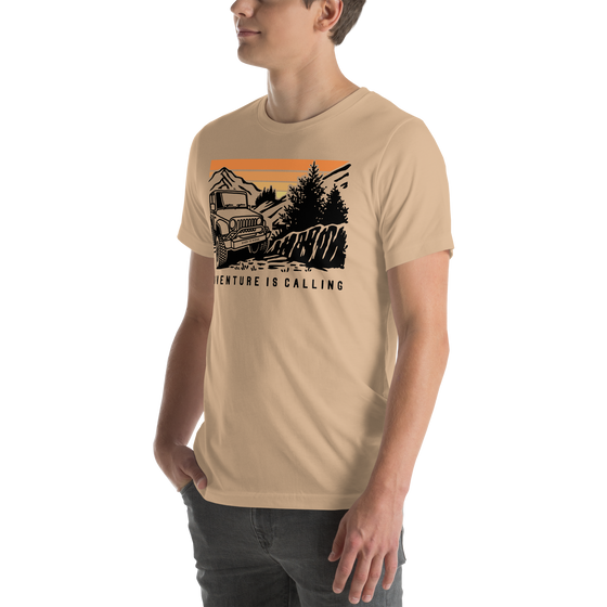 Men's T Shirt with graphic of a Jeep offroading in the mountains with the Words Adventure is Calling from River to Ridge Clothing brand worn by a young guy