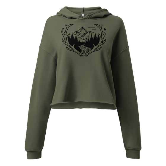 Womens crop hoodie with antler logo and mountains on it, says adventure awaits. in olive green