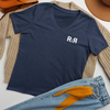 Women's R2R V Neck T shirt from River to Ridge Clothing Brand, laid out flat with jeans and a sweater